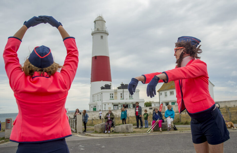 Miss High Leg Kick 2018 Two figures dancing in front of a lighthouse
